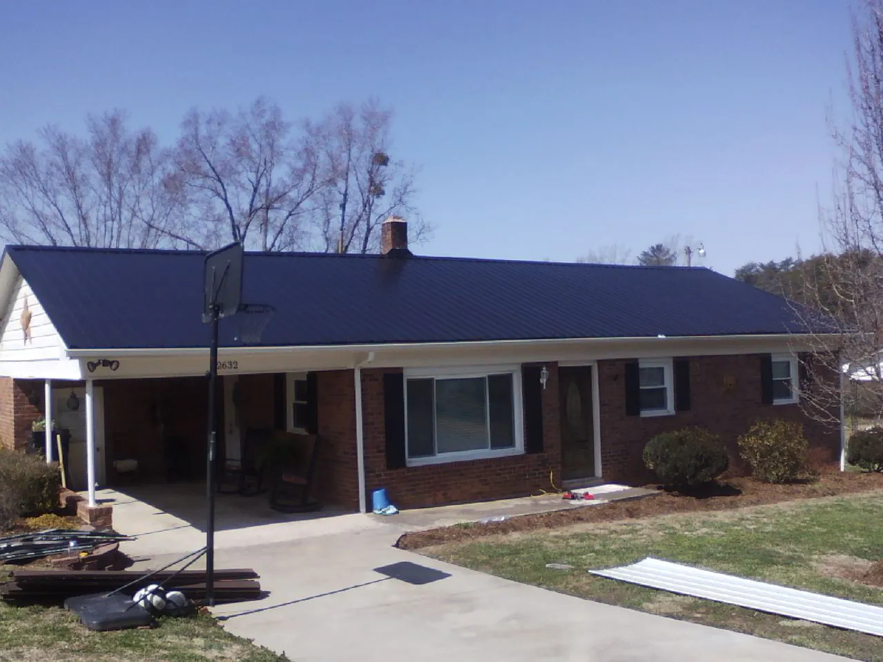 Finished dark blue metal roof on a brick ranch with a carport in Chesterfield